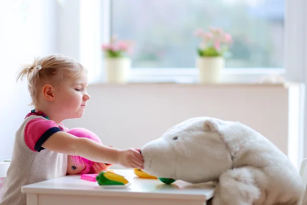 Småbarn flicka som leker med leksaker inomhus — Stockfoto