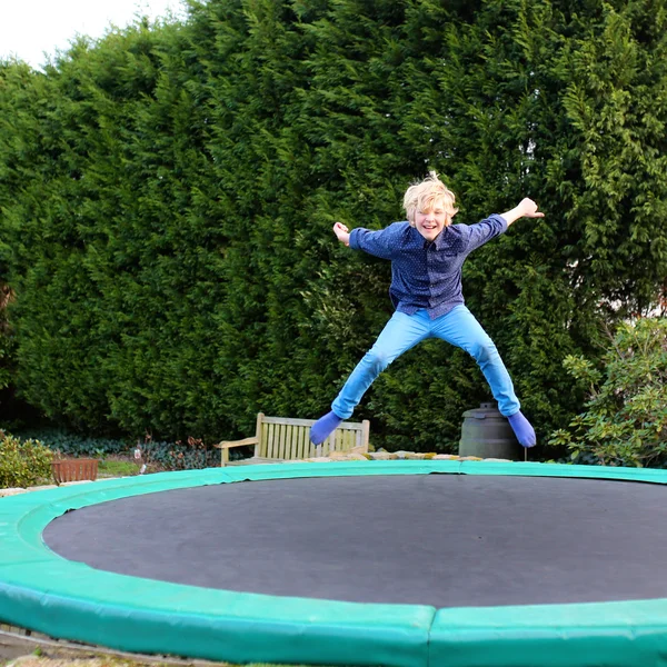 Felice ragazzo che salta sul trampolino — Foto Stock