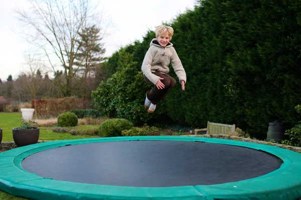 Niño feliz saltando en el trampolín —  Fotos de Stock