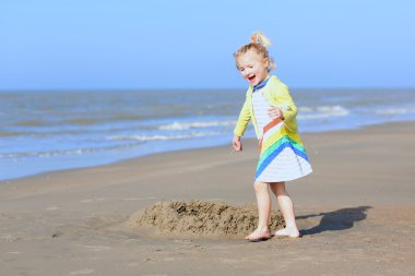 Kumsalda oynayan küçük kız.