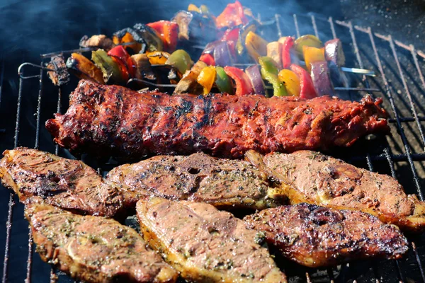 Assorteret kød og grøntsager på grillen - Stock-foto