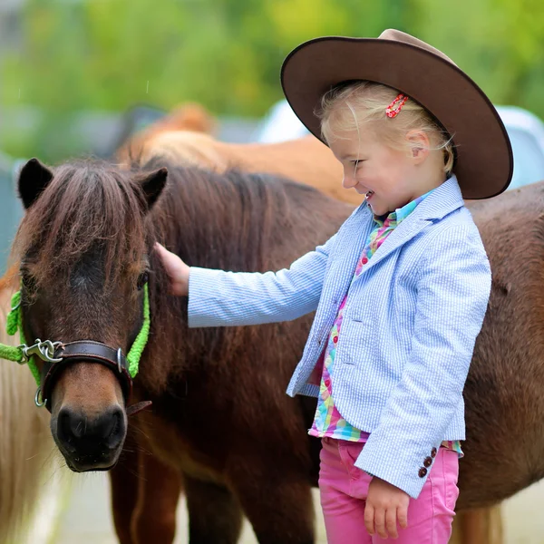 Linda niña cuidando de pony — Foto de Stock