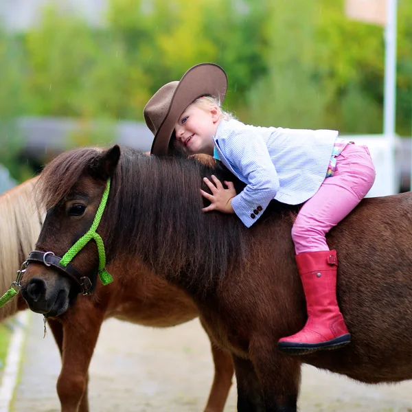 Cute little girl taking care about pony — Stock Photo, Image