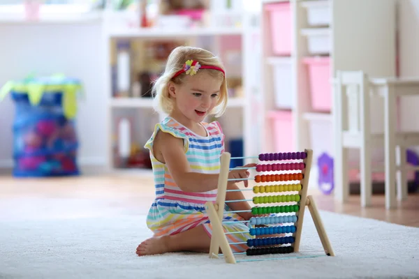 Happy toddler girl playing with abacus — Stock Photo, Image