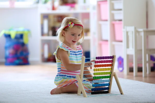 Menina criança feliz brincando com ábaco — Fotografia de Stock