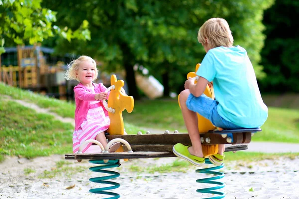 Bambini che oscillano nel parco giochi — Foto Stock