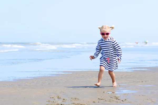 Lykkelig småbarnsjente nyter sommerdagen på stranden – stockfoto