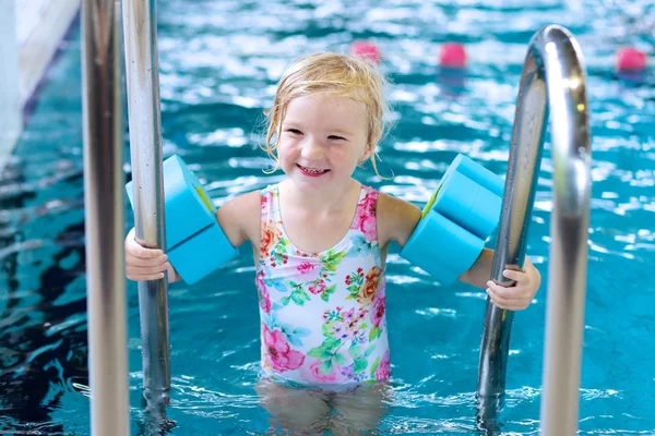 Спортивная маленькая девочка плавает в бассейне — стоковое фото