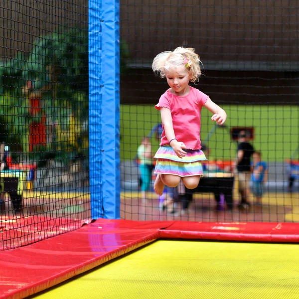 Aktiv liten flicka hoppar på studsmatta — Stockfoto