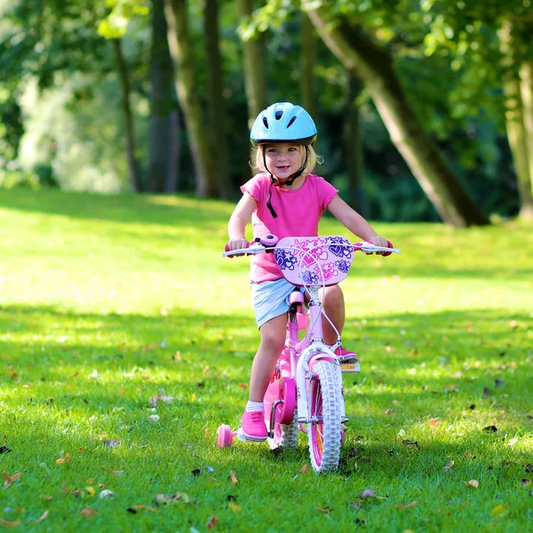 Niña pequeña montando con su bicicleta — Foto de Stock