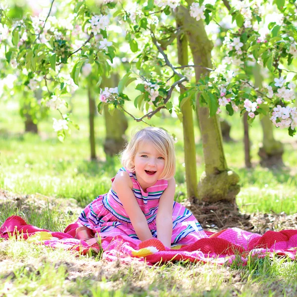 Little girl playing in blossoming fruit garden — Stock Photo, Image