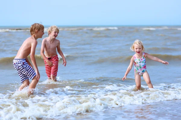 Glada barn plaska i havet — Stockfoto