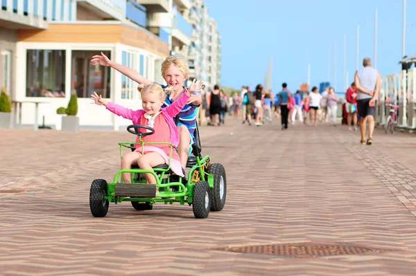 Kids riding pedal car on the beach — Stock Photo, Image