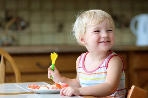 Healthy little girl eating salad in the kitchen — Stock Photo, Image