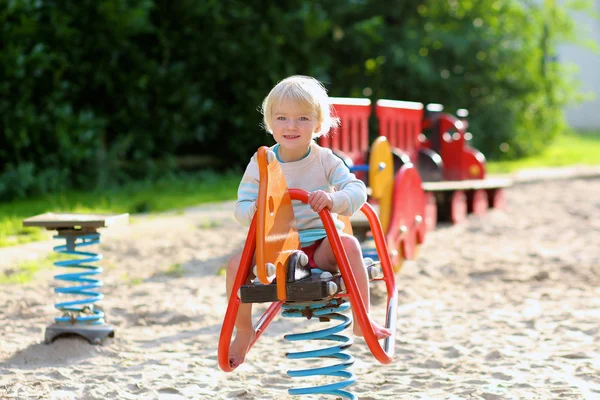 Menina pré-escolar feliz se divertindo no parque infantil — Fotografia de Stock