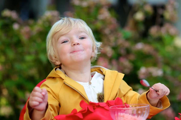 Cute dziewczynka jedzenie lody w kawiarni na świeżym powietrzu — Zdjęcie stockowe