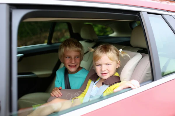 Bruder und Schwester sitzen sicher im Auto — Stockfoto