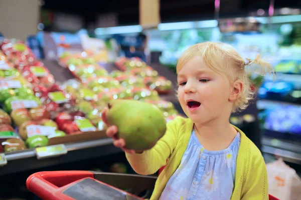 Linda niña comprando frutas en el supermercado —  Fotos de Stock