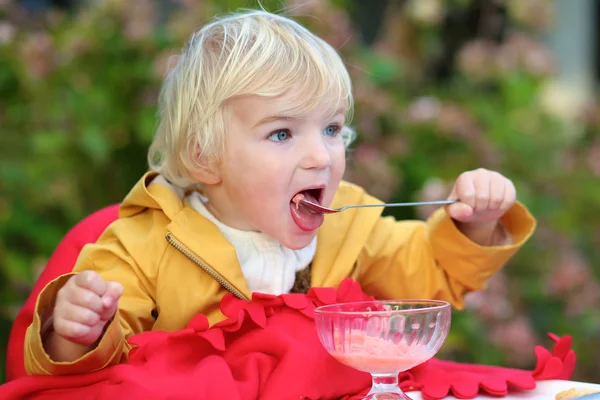 Süßes kleines Mädchen isst Eis im Café draußen — Stockfoto