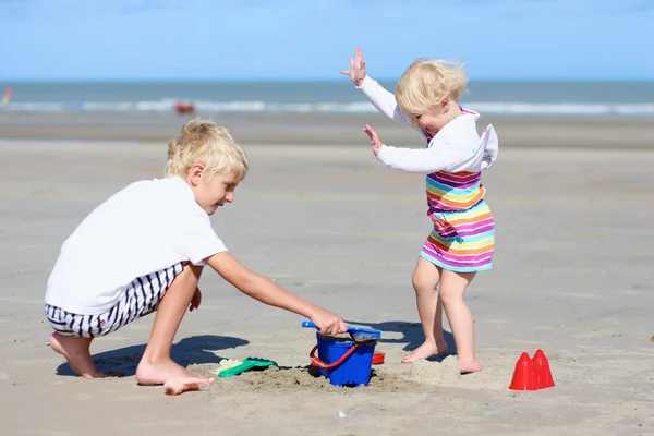 Bruder und schwester spielen am strand — Stockfoto