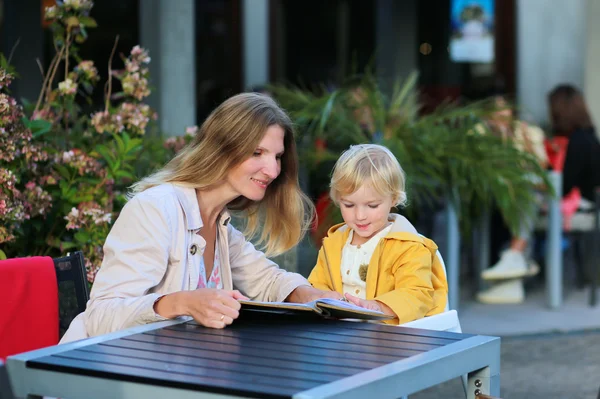 Мать и маленькая дочь отдыхают в кафе на открытом воздухе — стоковое фото