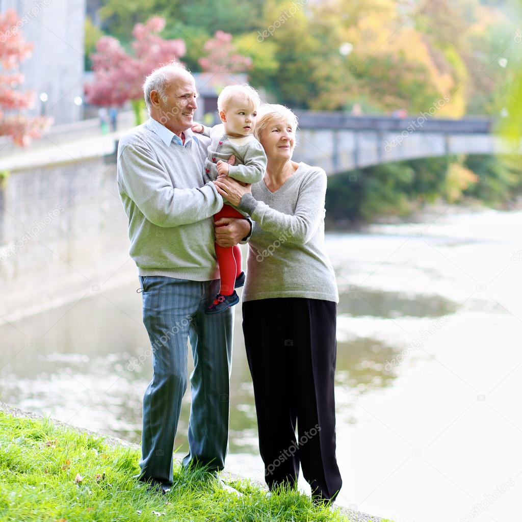 Grandparents with granddaughter walking in the park
