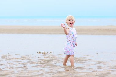 Kumsalda oynarken mutlu bebek kız
