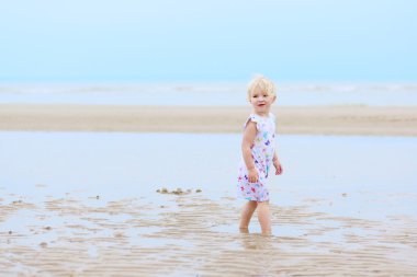 Kumsalda oynarken mutlu bebek kız