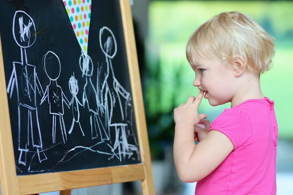 Preschooler girl drawing on black board — Stock Photo, Image