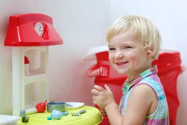 Preschooler dívka si hraje s hračkou kuchyně — Stock fotografie