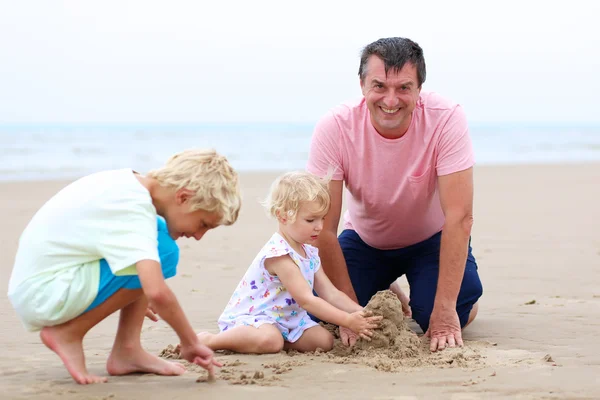 Pai com crianças brincando na praia — Fotografia de Stock