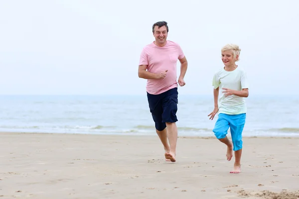 Father and son running no the beach — Stock Photo, Image