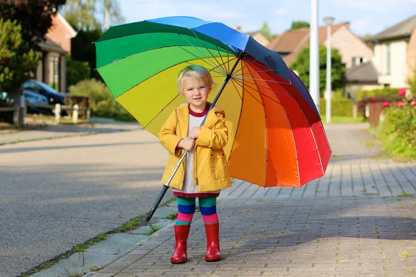 Liten flicka gå med färgglatt paraply — Stockfoto