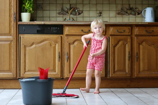 Preciosa niña preescolar fregando el suelo en la cocina —  Fotos de Stock