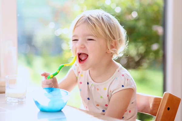 Meisje met havermout voor het ontbijt — Stockfoto