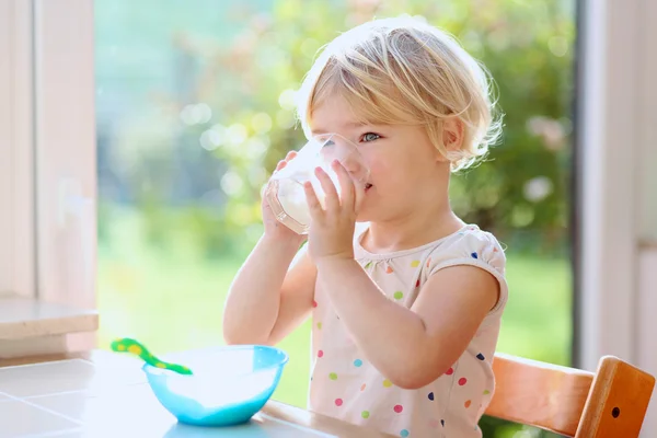 Маленькая девочка ест овсянку на завтрак — стоковое фото