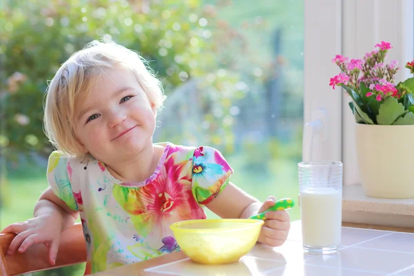 Barn girl äter frukost hemma — Stockfoto