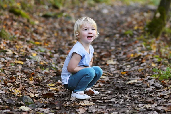 Förskolebarn tjej att ha kul i skogen — Stockfoto