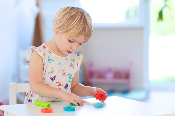 Niña pequeña creando con dinero de juego — Foto de Stock