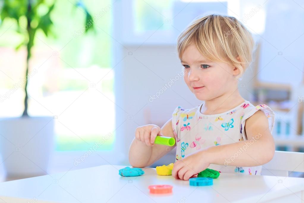 Toddler girl creating with play dough