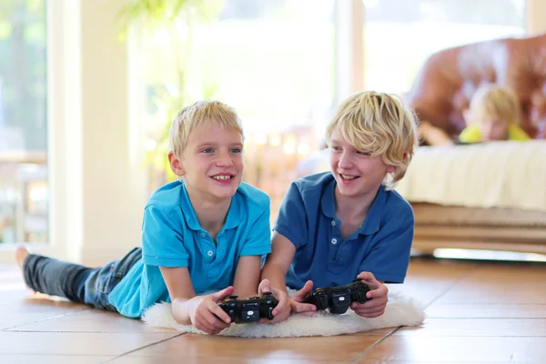 Δύο αδέλφια που παίζουν βιντεοπαιχνίδια στο σπίτι — Φωτογραφία Αρχείου