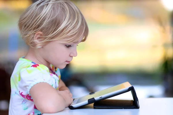 Девочка, играющая с планшетным компьютером — стоковое фото
