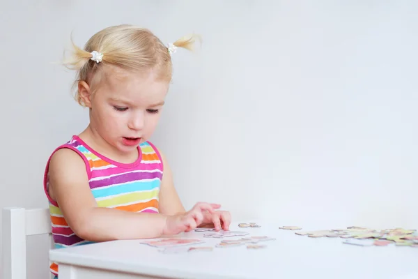 Toddler girl assembling jigsaw puzzle — Stock Photo, Image