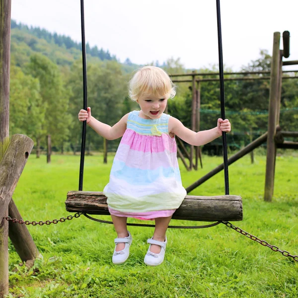 Barn girl har roligt på lekplatsen — Stockfoto