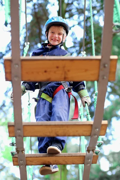 Ragazzo avventuroso arrampicata nel parco — Foto Stock