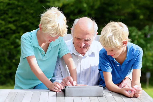 Grandkids teaching grandpa to use tablet pc — Stock Photo, Image