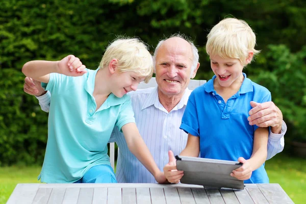 Vnoučata učil děda použití počítače tablet pc — Stock fotografie