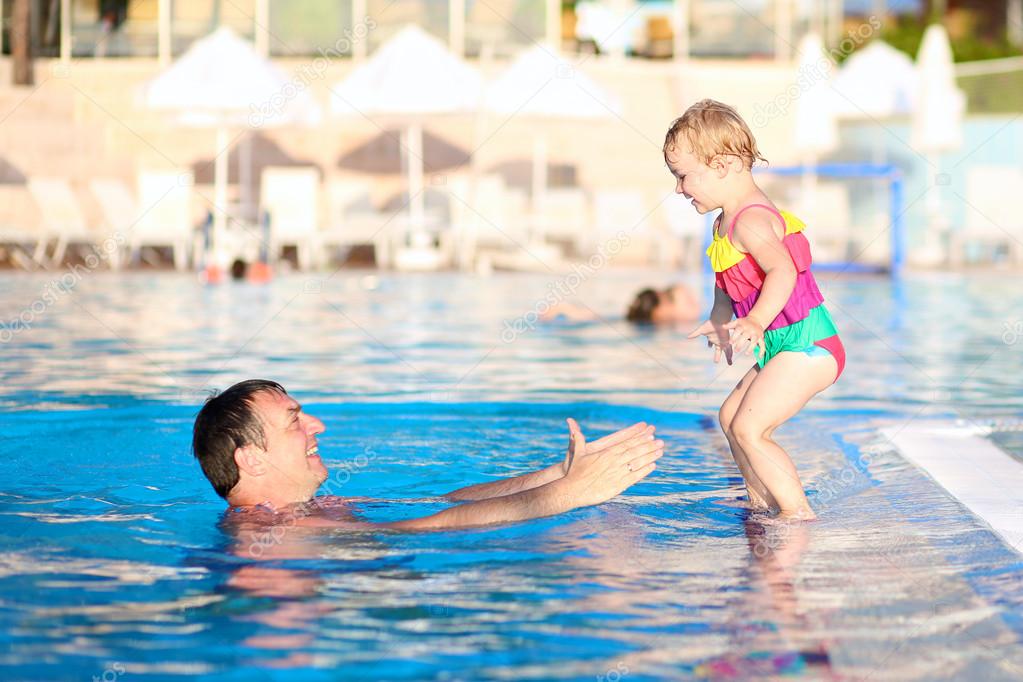 Father and daughter having fun in swimming pool