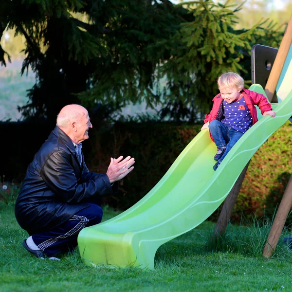Avô e neta no parque infantil — Fotografia de Stock