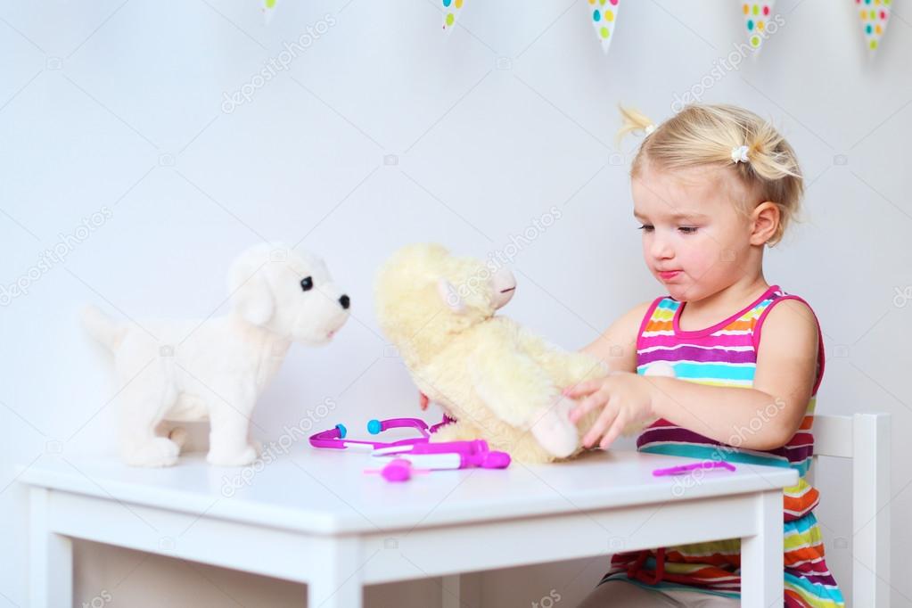 Little girl playing doctor with toys